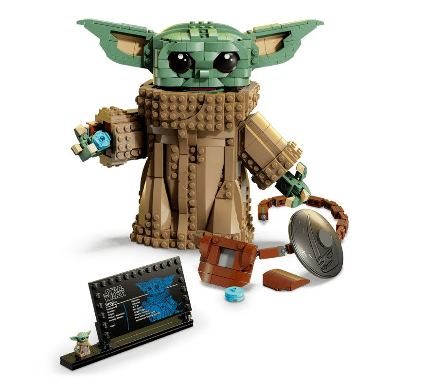 LEGO 75446 Grogu (Mandalorian Apprentice) by LEGO is a buildable model from Star Wars: The Mandalorian, featuring Grogu’s large ears, expressive eyes, brown robe, fun accessories, a nameplate, and a mini figure. An array of small LEGO Star Wars pieces is displayed in front.