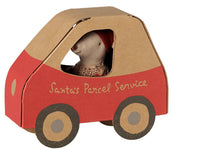 The Maileg Christmas Mouse, Little Sister in Car Box by Maileg features a small festive mouse wearing a red hat, nestled inside a charming red and brown cardboard car labeled “Santa’s Parcel Service”—a perfect addition for imaginative holiday play.