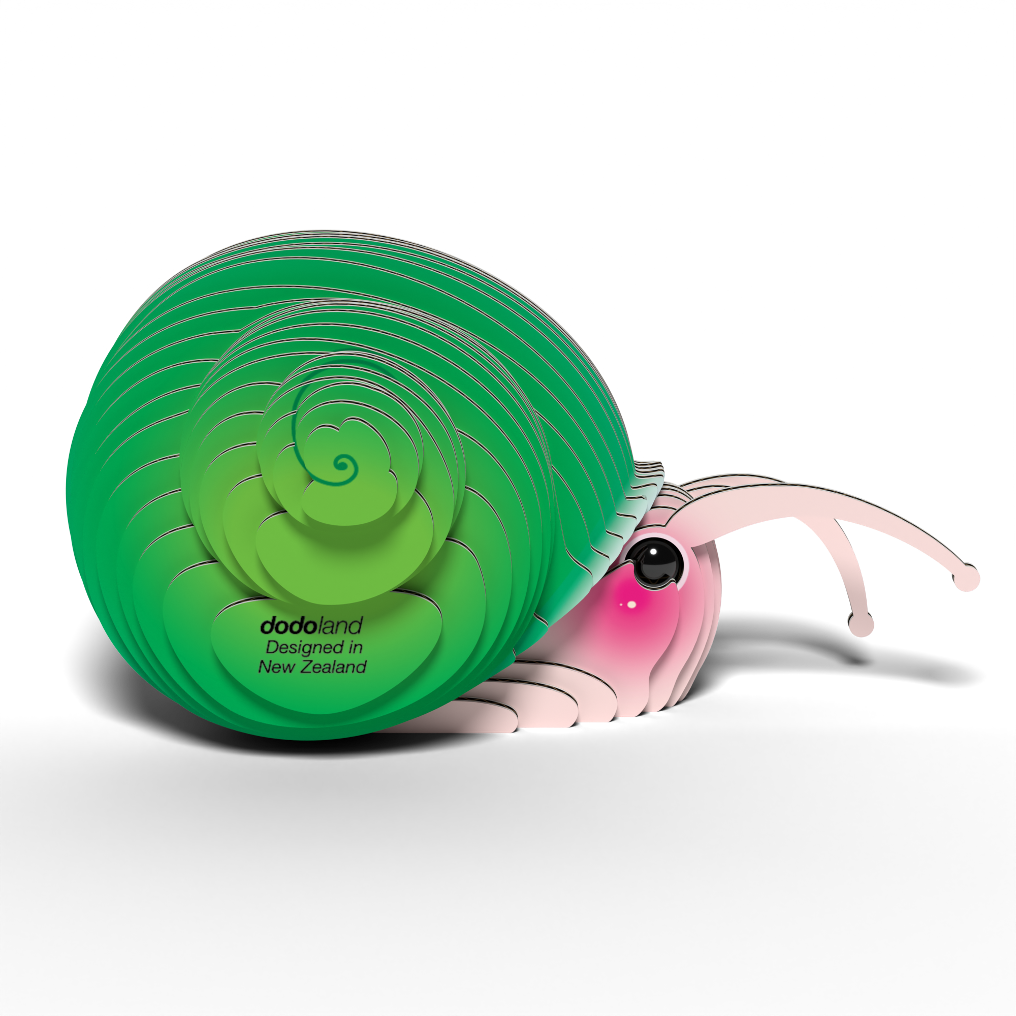 The EUGY Snail 3D Puzzle by Eugy is a cute, eco-friendly toy with a bright green spiral shell, pink face, blushing cheek, large eye, and “dodoland Designed in New Zealand” printed on its shell.