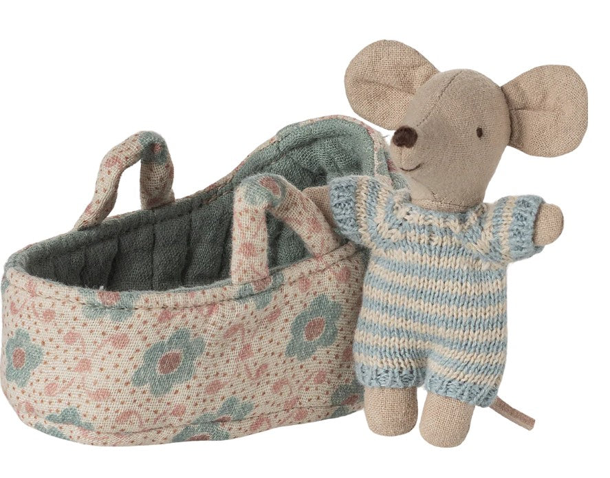 The Maileg Baby Mouse In Carry Cot - Blue features a small doll in a blue and white striped outfit, nestled in a soft floral-patterned carry cot with handles, all from the brand Maileg.