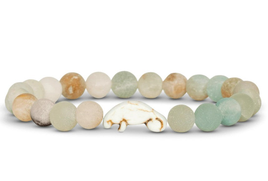 The fahlo Drift - Sky Stone Manatee bracelet features round, matte pastel stones and a manatee-shaped center stone—a stylish way to show your support for wildlife conservation.