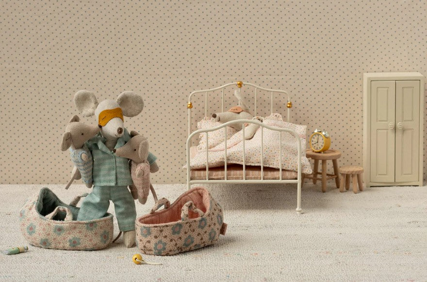 Maileg's Baby Mouse in Carry Cot - Blue rests in a charming miniature bedroom with bed, wardrobe, clock, nightstand, floral bags, pacifiers, and soft details for cozy play.