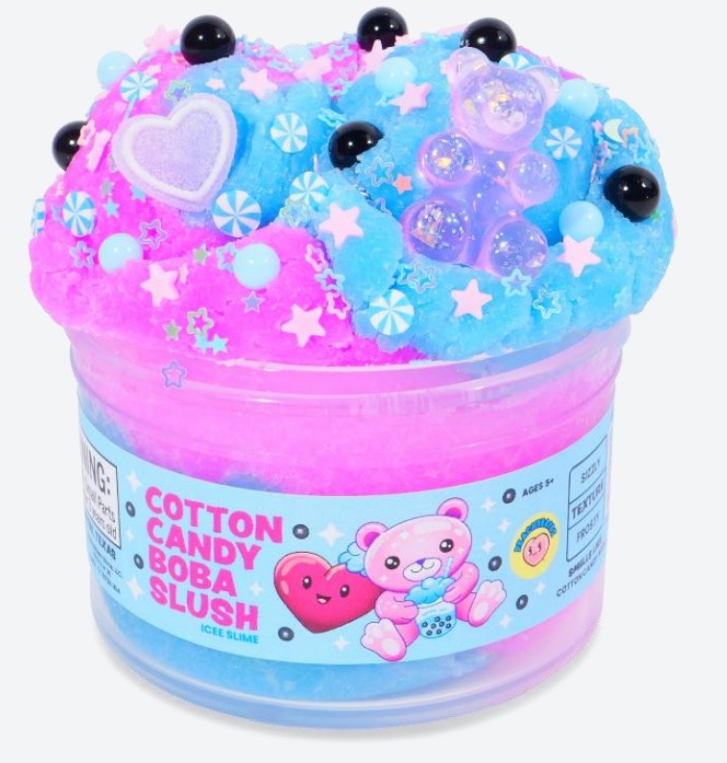 A clear jar labeled Cotton Candy Boba Slush Slime from Peachybbies Slime contains pink and blue fluffy slime with a delightful slushy texture, topped with beads, stars, and candy-shaped charms. The label features cute cartoon bears and hearts, making this sensory slime both adorable and fun to play with.