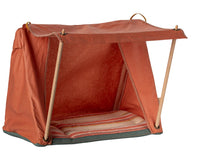 The Maileg Happy Camper Tent, Mouse by Maileg features an orange open-sided design with wooden poles and a striped cushion, creating the perfect setting for imaginative camping adventures and playtime fun.